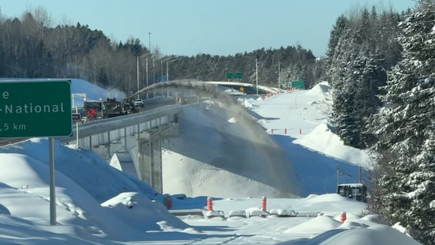 Un camion envoie de la neige dans une rivière.