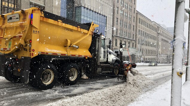 Un camion qui déneige une rue.