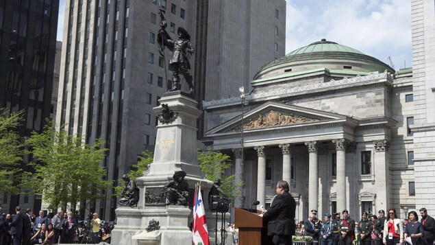 Denis Coderre prononce un discours devant une foule sur la place d'Armes.