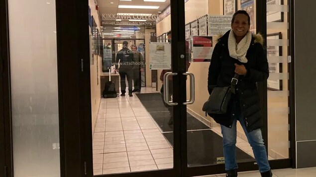 Une femme devant une porte.