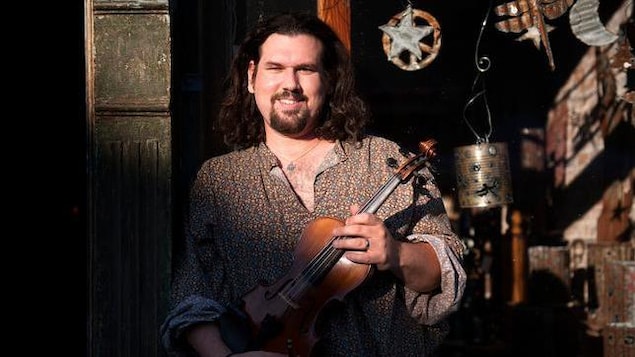 Le chanteur Dennis Stroughmatt avec un violon. Le chanteur Dennis Stroughmatt avec un violon.