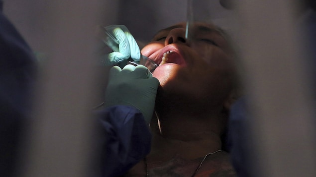 Un dentiste traite une patiente.