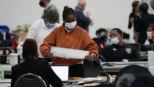 Des employés d'élection dépouillent des votes reçus par la poste.