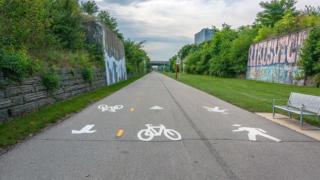 Un piste cyclable et piétonnière est entouré de zones boisées Un piste cyclable et piétonnière est entouré de zones boisées