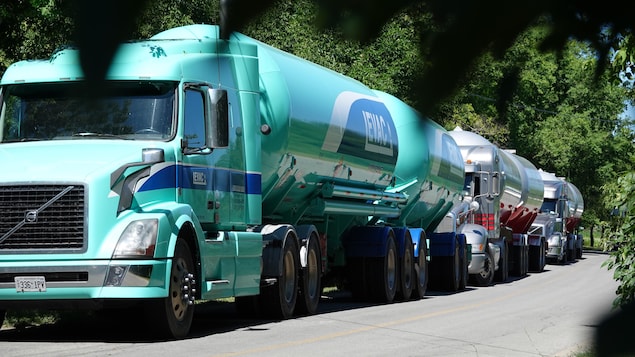 Trois camions citernes faisant la queue sur une route. Trois camions citernes faisant la queue sur une route.