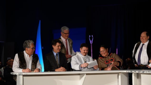 Le premier ministre Justin Trudeau, le premier ministre du Nunavut, P.J. Akeeagok, le ministre des Affaires du Nord Dan Vandal et le président de Nunavut Tunngavik Inc., Aluki Kotierk, signent l'accord de transfert des responsabilités au Nunavut à Iqaluit, le jeudi 18 janvier 2024.
