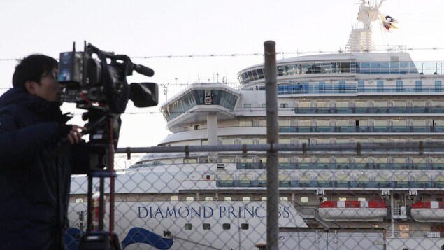 Un caméraman filme le Diamond Princess depuis le rivage.
