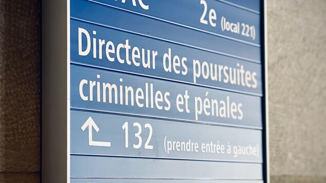 Affiche où l'on peut lire Directeur des poursuites criminelles et pénales avec une flèche.