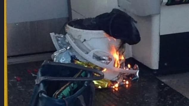 Un passager a photographié un sac déposé dans un seau en plastique, entouré de matière plastique, en feu dans un wagon de la rame de métro attaquée. Un passager a photographié un sac déposé dans un seau en plastique, entouré de matière plastique, en feu dans un wagon de la rame de métro attaquée.