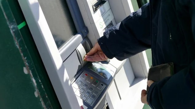 Un client à une distributrice de billets bancaires.