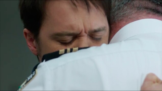 Deux hommes se prennent dans les bras. Deux hommes se prennent dans les bras.