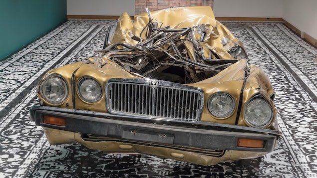 Photo d'une voiture écrasée exposée sur un tapis Photo d'une voiture écrasée exposée sur un tapis