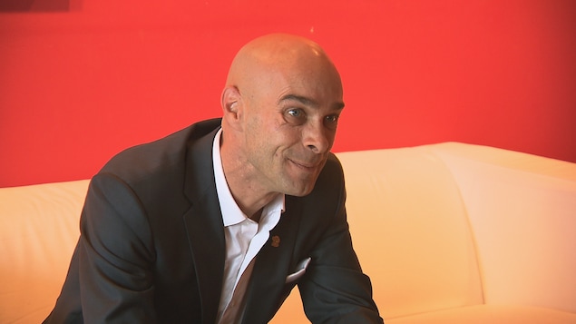 Djanick Michaud assis sur un sofa.