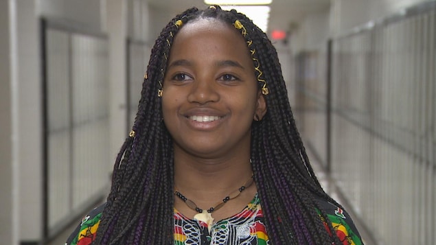 Portrait d'une jeune adolescente de couleur noire avec de longs cheveux tressés qui sourit. Portrait d'une jeune adolescente de couleur noire avec de longs cheveux tressés qui sourit.