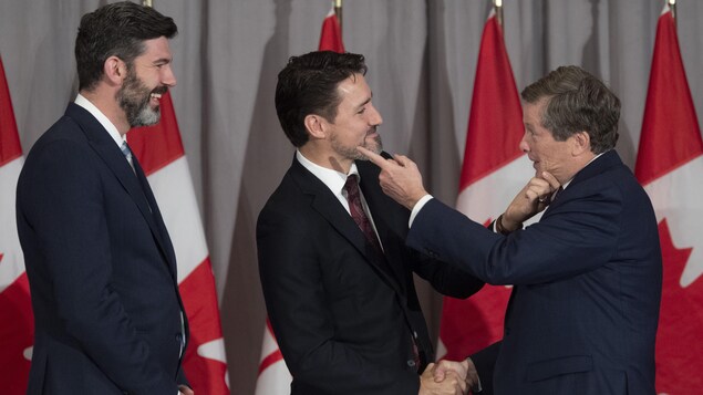 Le premier ministre canadien, Justin Trudeau, et le maire de Toronto, John Tory, se tiennent le menton sous le regard du maire d'Edmonton, Don Iveson, lors d'une rencontre des maires des grandes villes canadiennes à Ottawa, le 6 février 2020.