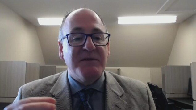Donald Desroches, dans un bureau, parle face à la caméra. Donald Desroches, dans un bureau, parle face à la caméra.