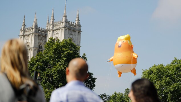 Des passants regardent l'énorme ballon à l'effigie de Trump. Des passants regardent l'énorme ballon à l'effigie de Trump.