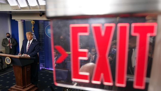 Donald Trump derrière un panneau Exit.