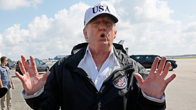 Donald Trump porte une grande casquette blanche, où il est inscrit "USA". Il se trouve sur le tarmac d'un aéroport à Fort Myers, en Floride. Donald Trump porte une grande casquette blanche, où il est inscrit "USA". Il se trouve sur le tarmac d'un aéroport à Fort Myers, en Floride.