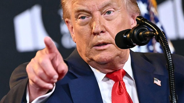 A headshot of man behind a microphone. 