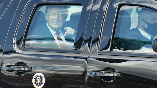 Donald Trump sourit, le doigt pointé, à travers la vitre d'une voiture, à son arrivée à Mar-a-Lago, en Floride.