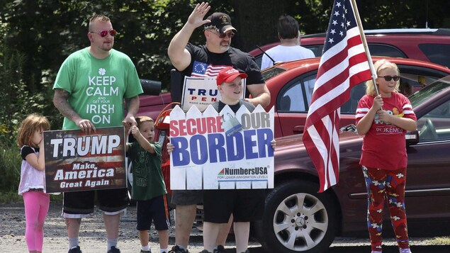Ils tiennent des pancartes le long d'une route. 