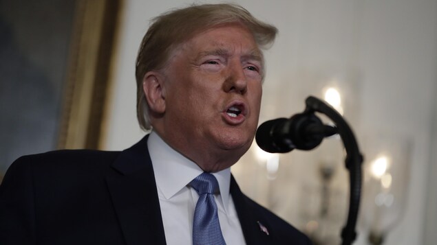 Le président Donald Trump parle dans un micro à la Maison-Blanche.
