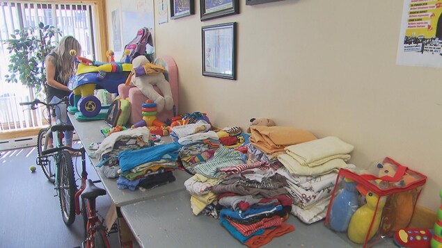 Des jouets et des vêtements pour enfants sont rassemblés sur une table. Des jouets et des vêtements pour enfants sont rassemblés sur une table.