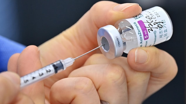  Une infirmière tient une dose du vaccin d'AstraZeneca. Elle s'en sert pour remplir une seringue.