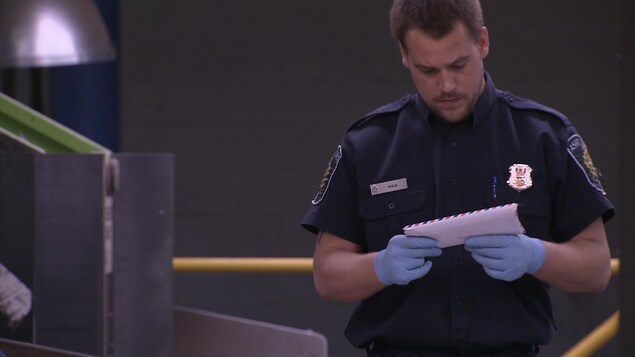 Un agent des services douaniers examine une lettre. Un agent des services douaniers examine une lettre.