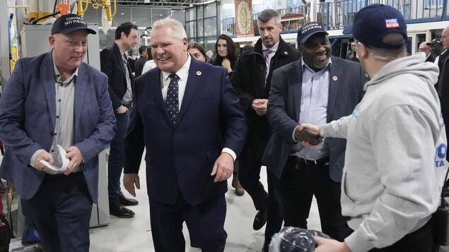 Doug Ford sort d'une usine après une annonce le 24 février 2025.