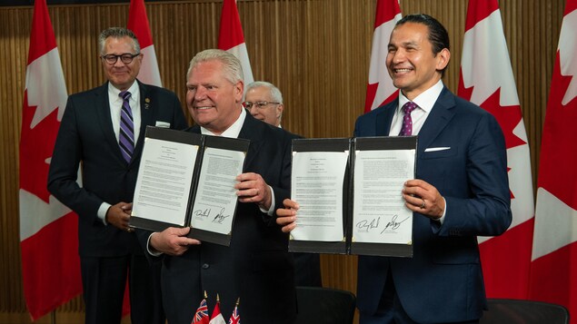 Doug Ford at Wab Kinew hawak ang mga pinirmahang kasunduan.