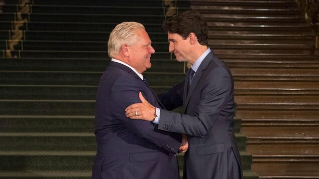 Doug Ford et Justin Trudeau se serrent la main.