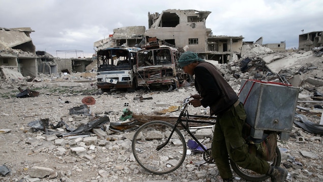 Un homme se promène avec sa bicyclette dans des ruines. Un homme se promène avec sa bicyclette dans des ruines.