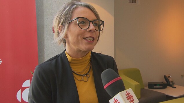 Une dame parle à un micro.