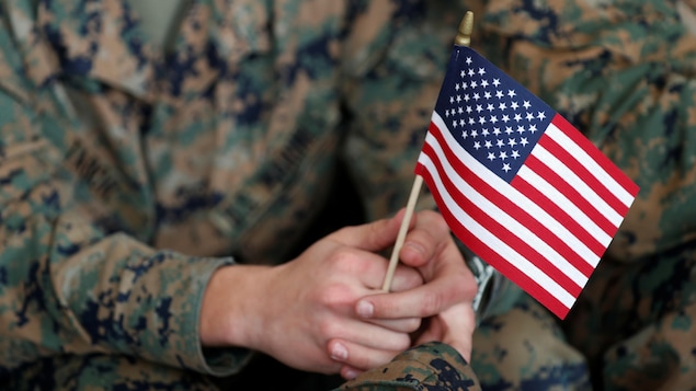Plan rapproché d'un petit drapeau américain tenu par un soldat.