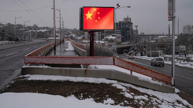 Un drapeau chinois apparaît sur un tableau d'affichage à proximité d'une autoroute.