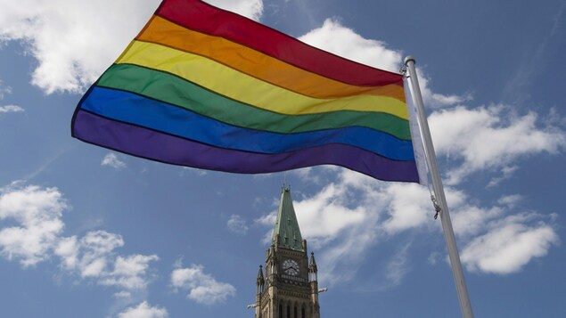 Le drapeau de la fierté flotte après une cérémonie sur la colline du Parlement, le 1er juin 2016, à Ottawa.
