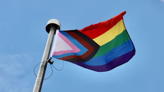 Un drapeau LGBTQ+ flotte au vent.
