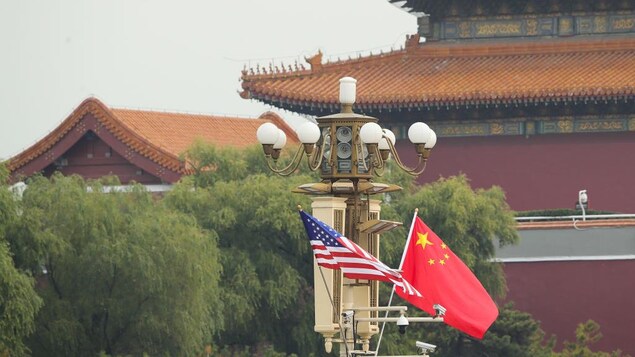 Des drapeaux des États-Unis et de la Chine flottent côte à côte dans un quartier de Pékin.