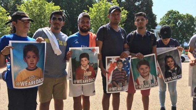 Six personnes tiennent des photos d'enfants devant eux. Six personnes tiennent des photos d'enfants devant eux.