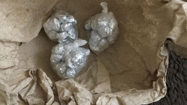 Trois petites boules enveloppées de plastique dont le contenu s'apparente à un type de drogue enveloppé dans du papier d'aluminium. Trois petites boules enveloppées de plastique dont le contenu s'apparente à un type de drogue enveloppé dans du papier d'aluminium.
