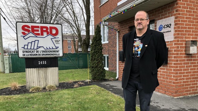Le président du syndicat prend la pose devant le bureau du syndicat.