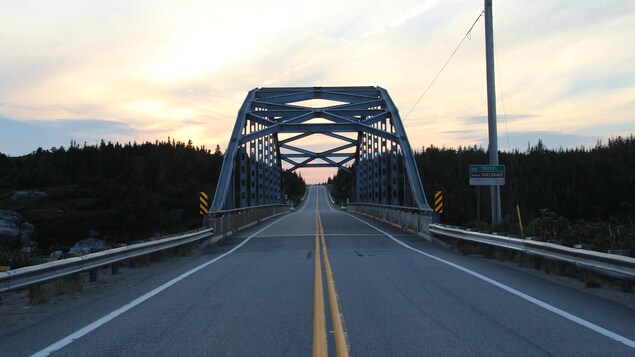 Une route et un pont au coucher du soleil.