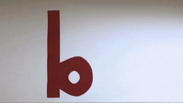 On voit un « b », en gros plan en rouge, à gauche et on voit un « d » apparaître à droite. Les deux images sont symétriques. On voit un « b », en gros plan en rouge, à gauche et on voit un « d » apparaître à droite. Les deux images sont symétriques.