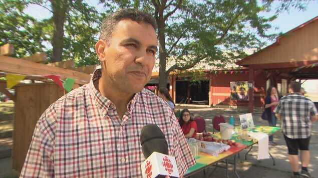Un homme en entrevue à la caméra dans un marché public extérieur de Gatineau. Un homme en entrevue à la caméra dans un marché public extérieur de Gatineau.