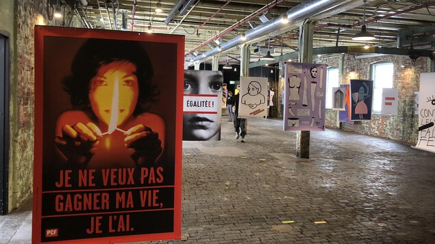 Des affiches féministes sont suspendues dans une ancienne usine.
