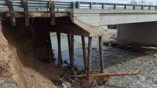 Un pont dont les piliers de soutien sont dénudés à cause de l'eau.