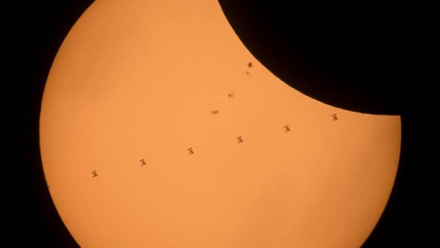 Cette image, réalisée à partir de sept clichés consécutifs, montre la Station spatiale internationale passant devant le Soleil durant l'éclipse. Cette image, réalisée à partir de sept clichés consécutifs, montre la Station spatiale internationale passant devant le Soleil durant l'éclipse.