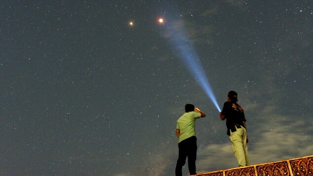 Des résidents de Padang, sur l'île de Sumatra, en Indonésie, observent l'éclipse totale de la Lune et la planète Mars à ses côtés. Des résidents de Padang, sur l'île de Sumatra, en Indonésie, observent l'éclipse totale de la Lune et la planète Mars à ses côtés.